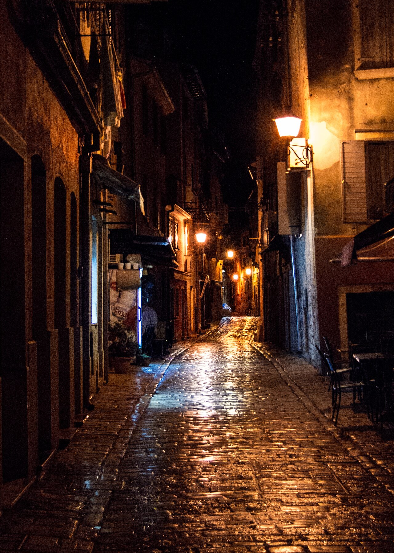 Wet cobblestone alley at night